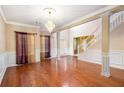 Elegant living room featuring hardwood floors, decorative columns, and a staircase, perfect for entertaining at 4312 Defoors Farm Trl, Powder Springs, GA 30127