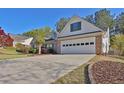 The long driveway leads to a two-car garage with a brick facade and well-maintained landscaping at 1112 Autumn Glen Way, Dacula, GA 30019