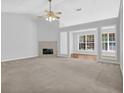 Open-concept living room features a fireplace and large windows that fill the space with natural light at 1112 Autumn Glen Way, Dacula, GA 30019