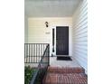 Covered front entry featuring a black front door with sidelight and a black metal handrail at 2939 Stonecrest Ln, Lithonia, GA 30038