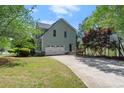 Rear exterior featuring an attached two-car garage and well maintained lawn at 5381 Fawn Meadow Ln, Powder Springs, GA 30127