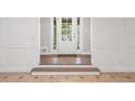 Bright foyer showcasing tile flooring, paneled walls, wood flooring steps, and a white front door at 3860 Rajean Dr, Lawrenceville, GA 30044