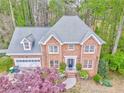 An impressive two-story brick home featuring an attached garage and landscaped front yard at 4327 Saint Michaels Dr, Lilburn, GA 30047