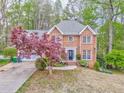 Beautiful brick home featuring mature trees, manicured lawn, and attached two car garage at 4327 Saint Michaels Dr, Lilburn, GA 30047