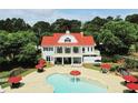 A pool with umbrellas and outdoor seating next to a large building with a red roof and white siding at 657 Egrets Landing #54, Covington, GA 30014