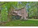 Charming home nestled amongst trees, featuring unique architecture and a well-manicured lawn at 2451 Cedar Fork Trl, Marietta, GA 30062