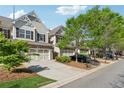 A row of townhouses with attached garages line a street in a well-kept community at 2894 Cross Creek Dr, Cumming, GA 30040