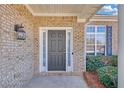 Close-up of the home's entryway, featuring a brick facade, a black door, and sidelight windows at 5013 Centennial Commons Nw Dr, Acworth, GA 30102