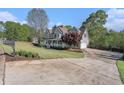 Beautiful home with a sprawling driveway, attached garage, a spacious yard, and meticulous landscaping at 60 Bartlett Way, Dallas, GA 30157