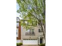 Charming townhome featuring a gray painted facade, complemented by an attached two-car garage and tasteful landscaping at 11302 Musette Cir, Alpharetta, GA 30009