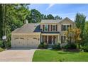 Inviting two-story home featuring a well-kept lawn and attached two-car garage at 2500 Kingsbrooke Ln, Duluth, GA 30097