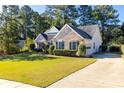 Inviting brick home with lush green lawn, showcasing the driveway and attached two car garage at 5494 White Cedar Ter, Sugar Hill, GA 30518