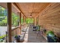 Cozy covered front porch featuring wood beams, ceiling fan, and comfortable seating at 135 Fiddle Crk, Social Circle, GA 30025