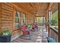 Relaxing covered front porch with wood ceiling and railing, ceiling fan and comfortable seating at 135 Fiddle Crk, Social Circle, GA 30025