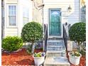 Close-up of a front door with manicured bushes and seasonal flowers in decorative pots at 2557 Summit Cove Dr # 128, Duluth, GA 30097