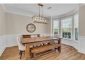 Dining room boasts natural light, a stylish light fixture, wainscoting, and hardwood floors at 2850 Dartmouth Pl, Cumming, GA 30041