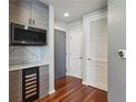 Hallway featuring a wine cooler, modern light fixtures, and hardwood floors at 860 Peachtree Ne St # 1417, Atlanta, GA 30308
