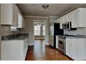 Modern kitchen featuring granite countertops, stainless steel appliances, and white cabinetry at 1550 Royale Castle Dr, Lawrenceville, GA 30043
