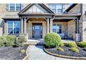 Charming two story brick home features a covered front porch and well-maintained landscaping at 2705 Fox Hunt Way, Cumming, GA 30041