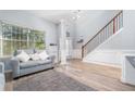 Bright living room with hardwood floors, large window, and staircase at 2984 Gayle Manor Ln, Snellville, GA 30078
