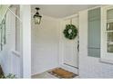 Charming, covered front porch of a white brick home featuring stylish light fixture and front door at 389 Valley Brook Ne Dr, Atlanta, GA 30342