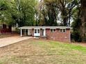Cozy brick house with a carport and a compact front yard surrounded by lush trees at 398 Windy Hill Se Rd, Marietta, GA 30060