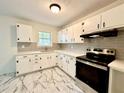 Bright kitchen featuring white cabinets, a modern tile backsplash, and stainless steel appliances at 398 Windy Hill Se Rd, Marietta, GA 30060