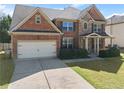 Inviting two-story brick home with a two-car garage and landscaped front yard at 4735 Belcrest Way, Cumming, GA 30040