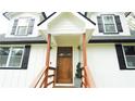 Welcoming front entryway with a solid wood door, decorative columns, and new porch and freshly painted exterior at 2638 Cleburne Pkwy, Powder Springs, GA 30127