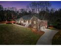 Attractive brick home with a covered porch, long driveway, and a well-kept lawn during twilight at 503 Clearwater Dr, Mcdonough, GA 30252