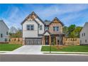 Attractive two-story home featuring a mix of brick and gray siding, and a well manicured front lawn at 3962 Adler Cir, Buford, GA 30519