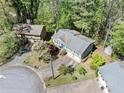 Aerial view of a home with a well-maintained lawn, blue front door and a two-car garage, set in a wooded neighborhood at 1842 Jarrett Dr, Lawrenceville, GA 30043