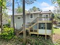 Backyard view showing a large wooden deck, screened in porch, and backyard with natural landscaping at 1842 Jarrett Dr, Lawrenceville, GA 30043