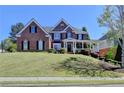 Charming two-story brick home with manicured lawn and welcoming front porch at 2123 Floral Ridge Dr, Dacula, GA 30019