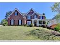 Attractive two-story brick home with manicured lawn and covered front porch at 2123 Floral Ridge Dr, Dacula, GA 30019