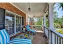 Relaxing front porch with brick flooring, comfortable seating, and decorative plants at 2123 Floral Ridge Dr, Dacula, GA 30019