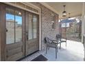 Covered front porch featuring double doors, brick walls, and seating for relaxing outdoors at 7751 Capps Ridge Ln, Douglasville, GA 30135