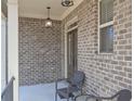 Cozy front porch with brick columns, ambient lighting, and comfortable seating at 7751 Capps Ridge Ln, Douglasville, GA 30135