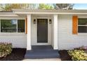 Close-up of the front entrance with gray door, sidelights, and decorative wood shutters at 974 Shirley Se St, Smyrna, GA 30082