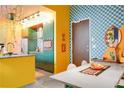 A funky kitchen with yellow lower cabinets, overhead track lighting, and stainless steel appliances at 130 Arizona Ne Ave # 415, Atlanta, GA 30307
