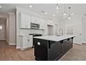 Modern kitchen featuring white cabinets, stainless appliances, and a large black island at 1616 Ruskin Way, Marietta, GA 30062