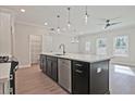 Open concept kitchen with stainless dishwasher, white counter tops, and wood flooring at 1616 Ruskin Way, Marietta, GA 30062