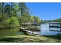 Dock with an attached walkway over the lake with boat parking at 934 Pine Cir, Woodstock, GA 30189