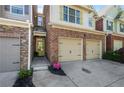 Inviting townhome exterior with brick accents, a two-car garage, and a neatly landscaped entrance at 2840 Smith Ridge Trce, Peachtree Corners, GA 30071