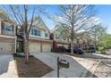 Exterior view of the townhomes shows brick accents, two-car garages and well-maintained landscaping at 2840 Smith Ridge Trce, Peachtree Corners, GA 30071