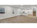Spacious living room with luxury vinyl plank floors open to kitchen and stairs at 668 Egrets Landing #64, Covington, GA 30014