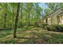 Lush green backyard with mature trees and a cozy deck, perfect for outdoor entertaining at 230 Oakmere Dr, Alpharetta, GA 30009
