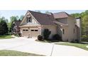 This home has a spacious driveway, two-car garage and neutral siding at 5095 Hamby Hollow Ln, Cumming, GA 30028