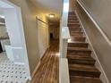 Inviting hallway with wood-look flooring and stairs leading to the upper level of the home at 6718 Roscommon Dr, Austell, GA 30168