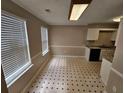 Bright kitchen and breakfast nook with tiled floor, white cabinets, and large windows at 6718 Roscommon Dr, Austell, GA 30168